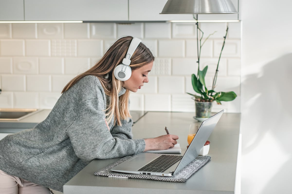 A young woman listening to online course indoors