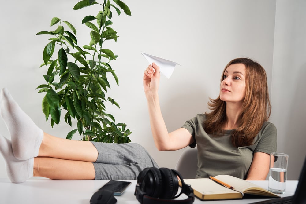 Woman Procrastinating by Flying Paper Planes